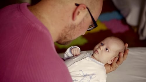 Jeune grand-père joue avec sa petite-fille nouveau-née
