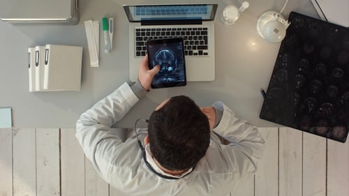 Top View of Man Using Tablet PC Against Medical Interface on Xray