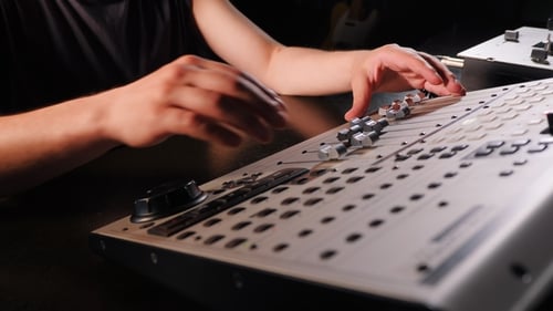 Unrecognizable Sound Producer or Engineer Rotates Scrolls Wheel on Mixing Console in Professional