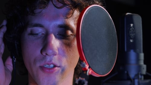 Young Handsome Singer Man Emotionally Writing Song in the Studio