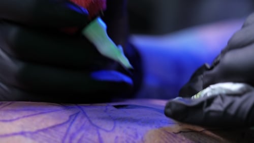 Tattoo Artist Demonstrates the Process of Getting Black Skull Tattoo with Paint