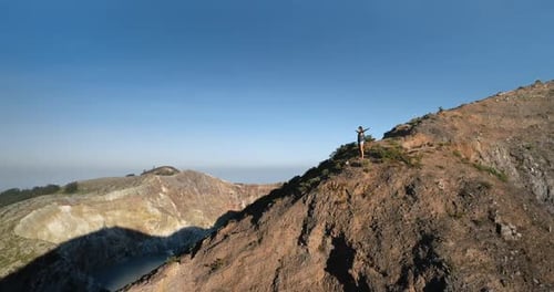 Woman Standing on Mountain Top with Hands Rise Up