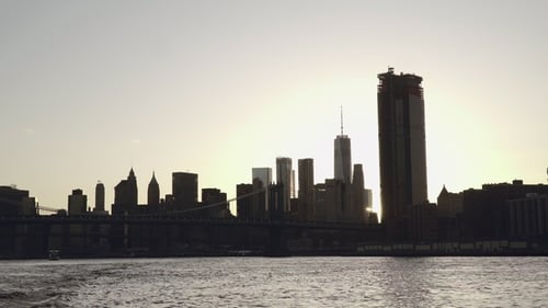 Una llamarada de sol al atardecer brilla en el horizonte del Bajo Manhattan y el puente de Brooklyn en Nueva York, Estados Unidos