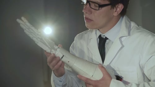 Le scientifique teste la main robotique en laboratoire