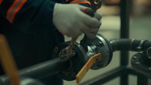 Hands Tightening Pipe Fitting in an Industrial Setting