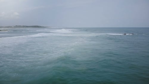 Drone Camera Follows Big Ocean Wave Reaching Exotic Tropical Shore and Crashing with White Foam
