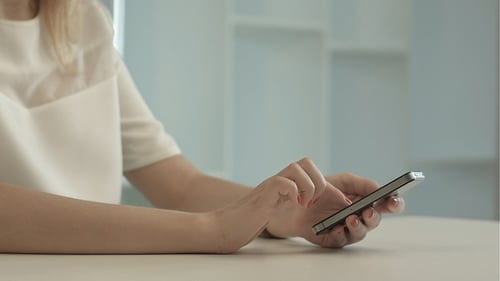 Woman Using Mobile Smart Phone Device Indoors
