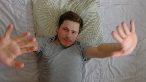 L'homme ouvre les yeux dans son lit après le sommeil