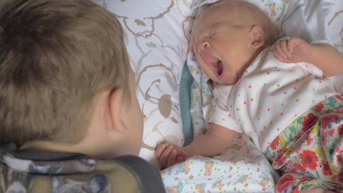 Niño cuidando a la hermana bebé
