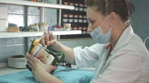 Dental Technician Crafting Dentures in Laboratory Setting