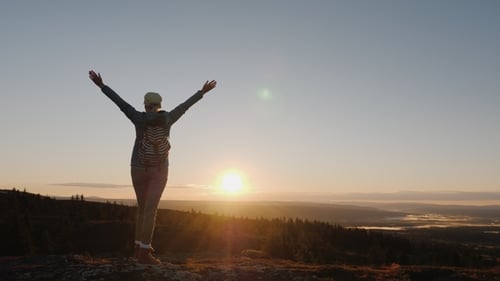 Une femme active arrive au sommet de la montagne avec une vue impressionnante en bas. Voyagez en