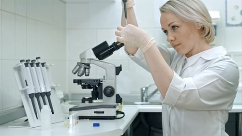 Woman Scientist Working with Pipette and Microscope