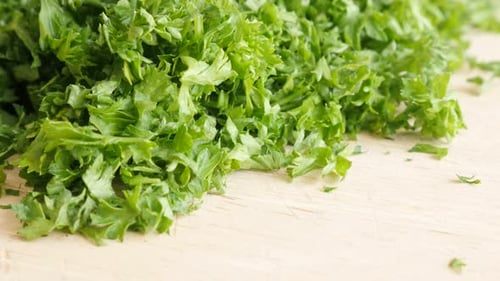 Parsley vegetable plant smaller pieces on cutting board 4K 3840X2160 UltraHD footage - Petroselinum