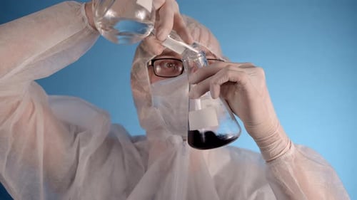 Máscara médica para hombre con traje protector, guantes, sostiene mezclas líquidas en frascos