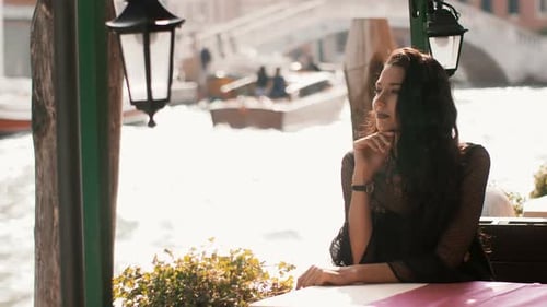 Travel Tourist Woman in Cafe Against Beautiful View on Venetian Chanal in Venice, Italy.