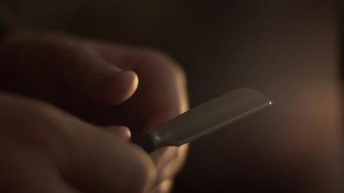 Hand Tests Sharpness of Blade with Thumb
