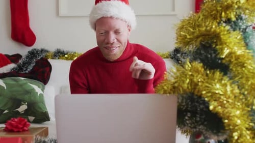 Man in Santa Hat Using Laptop at Christmas