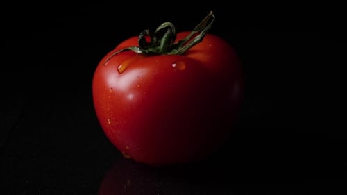 Drops of Water Dripping From Above Ripe Tomatoes. Frame. of a Drop of Water Dripping From a Tomato