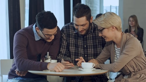 Friends Gather at Cafe Looking at Smartphone