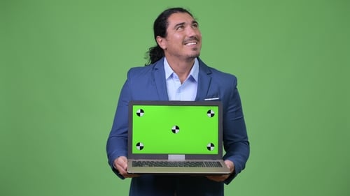 Handsome Businessman Thinking While Showing Laptop