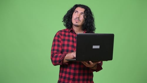Handsome Hipster Man Thinking While Using Laptop