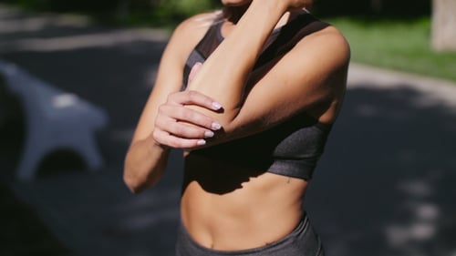 Athletic Woman Stretching Her Arms Outdoors