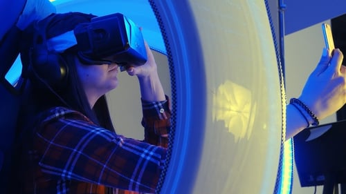 Woman Experiences Virtual Reality in Simulator Pod