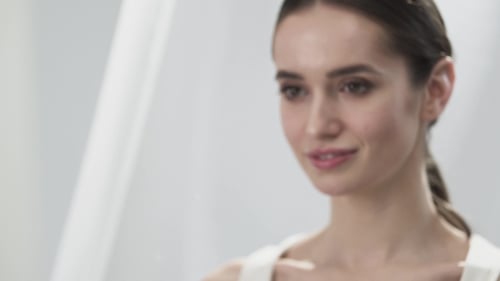 Woman Applying Skincare Product To Her Face