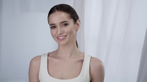 Smiling Woman Poses in White Sleeveless Top