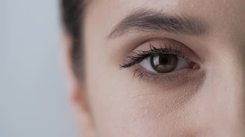 Woman Touches Skin Around Eye in Extreme Close-Up