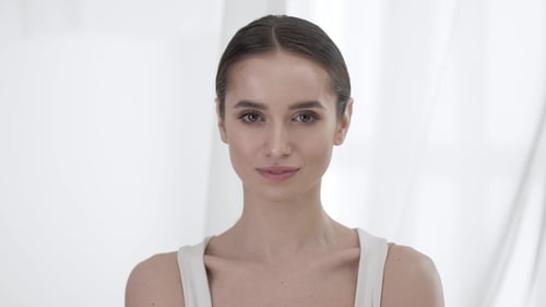 Woman Counts Using Fingers in Bright White Room