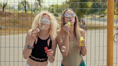 Schöne Hipster-Mädchen mit Sonnenbrille, die Spaß daran haben, Blasen im Freien