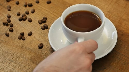 Männliche Hand nimmt heißen Kaffee zum Trinken