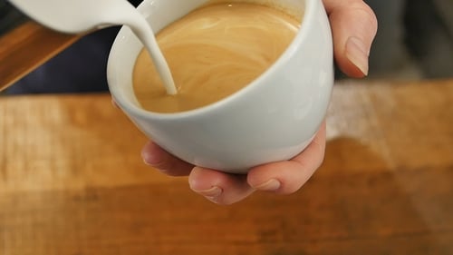 Pouring Milk into a Cup of Coffee