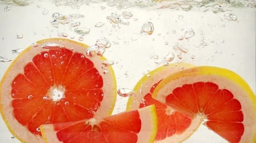 Grapefruit Wedges Falling in Water, Slow Motion