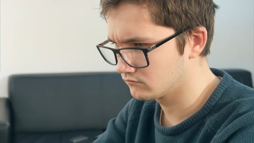 Male Student with Laptop Studying in the University Library