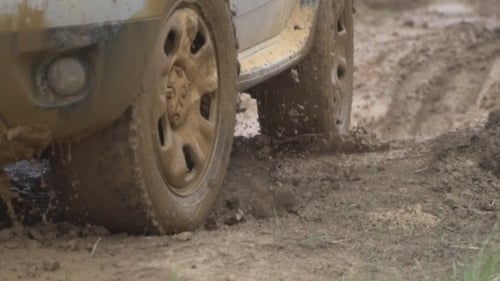 Powerful Towed Off-road Vehicle on Dirty Rural Road After Rain in Bad Weather