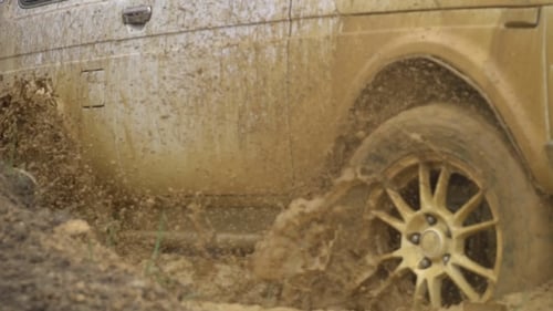 Beautiful Car in Rough Terrain. A Powerful SUV Is Towed in a Deep Puddle. Extreme Driving Conditions