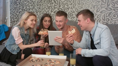 Grupo de amigos comendo pizza para viagem e assistindo programa no tablet