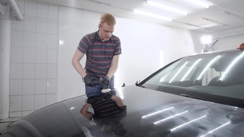 Man Detailing Black Car with Polishing Machine