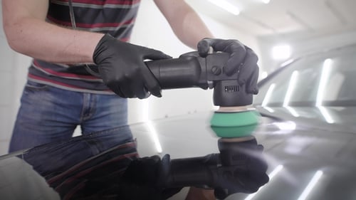 Professional Polishing Black Car Hood with Special Polishing Machine on a Car Service
