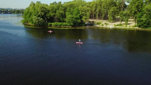 Three Young People Are Kayaking on the River