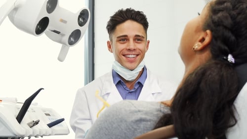 Dentist Smiles During Patient Checkup at Hospital