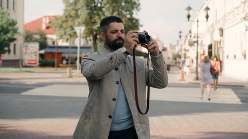 Stylish Man with Vintage Camera in Urban Setting