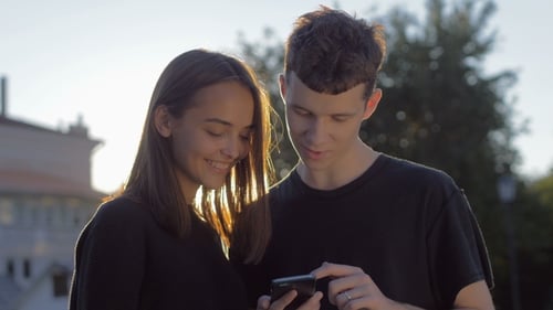 Young Adults Looking at Smartphone in City