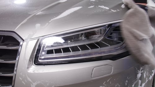 Detailer Wiping a Silver Car with Grey Cloth