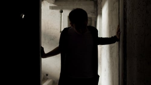 Yound Bad Looking Man Leans Against the Walls in an Abandoned Building
