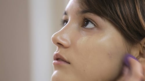 Brunette Applies Foundation with Makeup Sponge