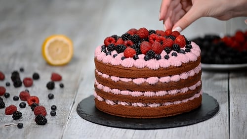 Cake Being Decorated with Fresh Summer Berries
