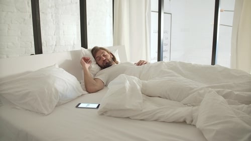 Man Wakes Up and Looks at Cell Phone